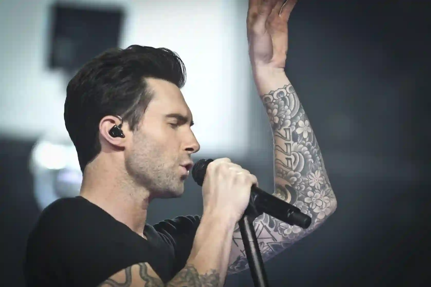 Adam Levine performing on stage with confident posture, exploring whether Adam Levine is a narcissist through his public persona